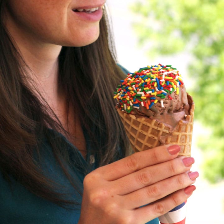 girl with waffle cone of chocolate with sprinkles