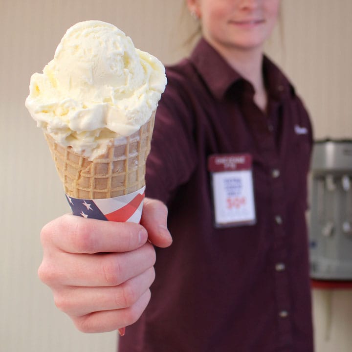 partner holding waffle cone of vanilla ice cream