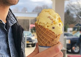 man holding butter pecan in a waffle cone