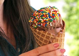 chocolate ice cream with sprinkles on a waffle cone