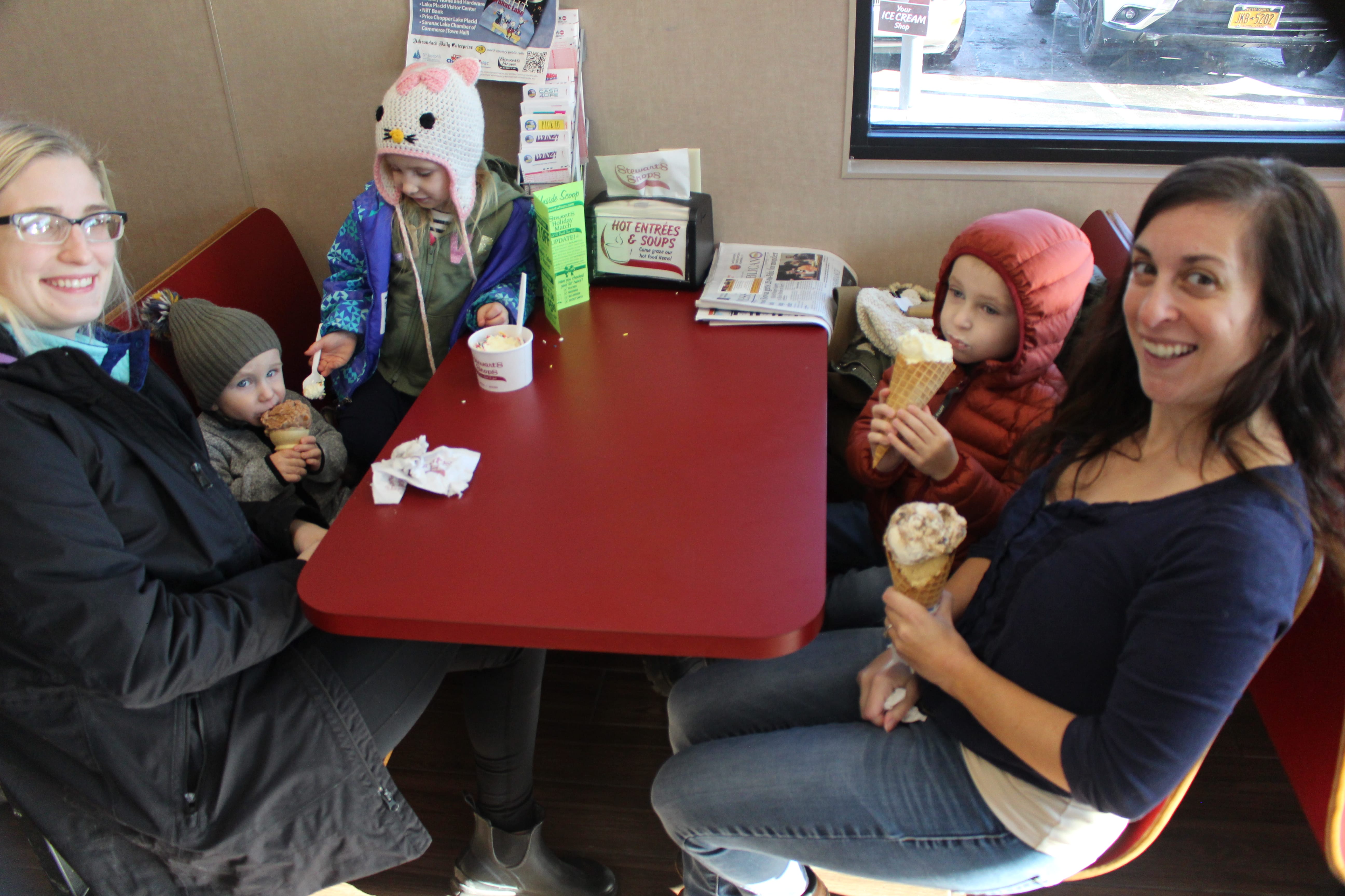 two women and three children enjoying ice cream