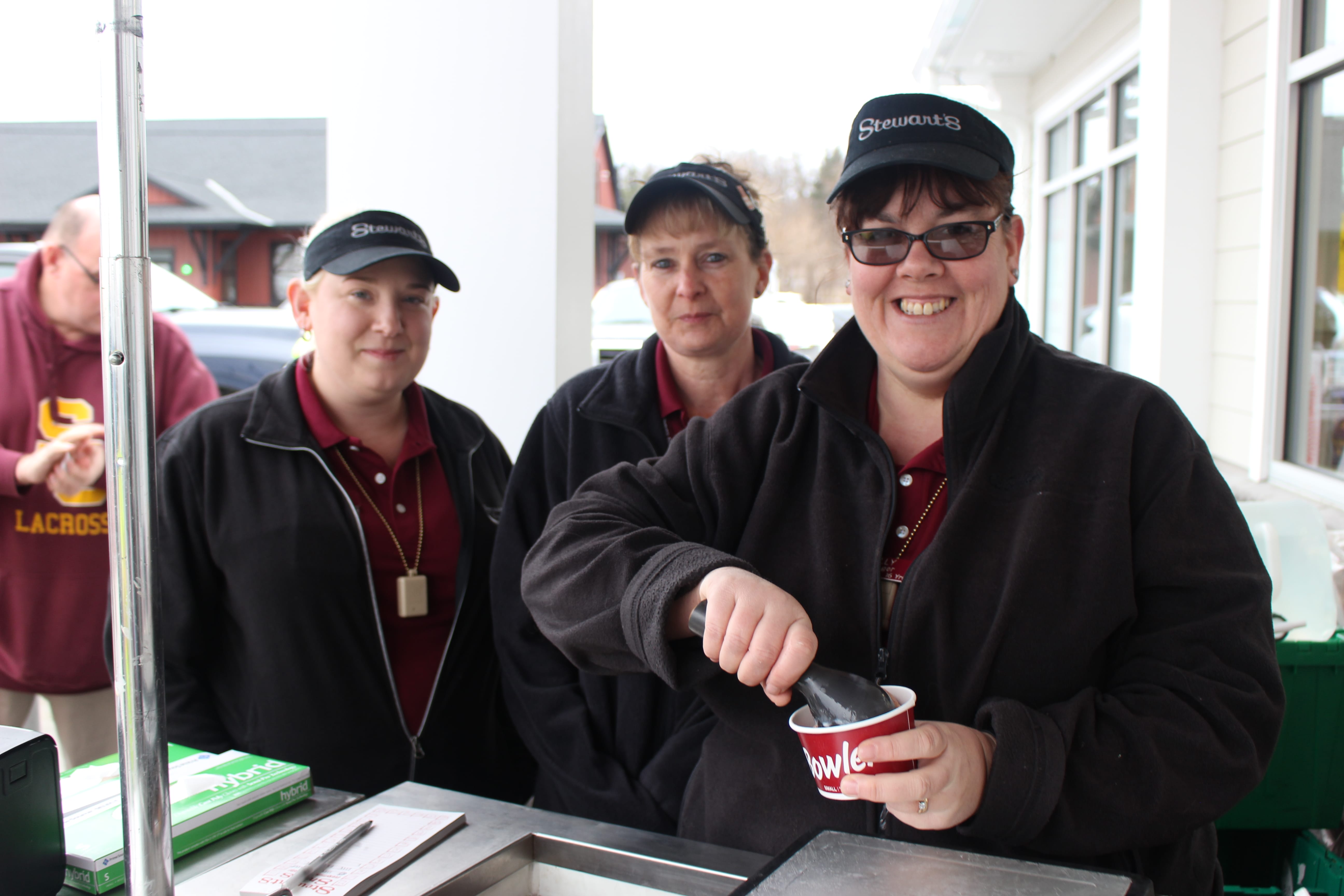 Three Stewarts employees selling ice cream outside the new shop during the grand opening event