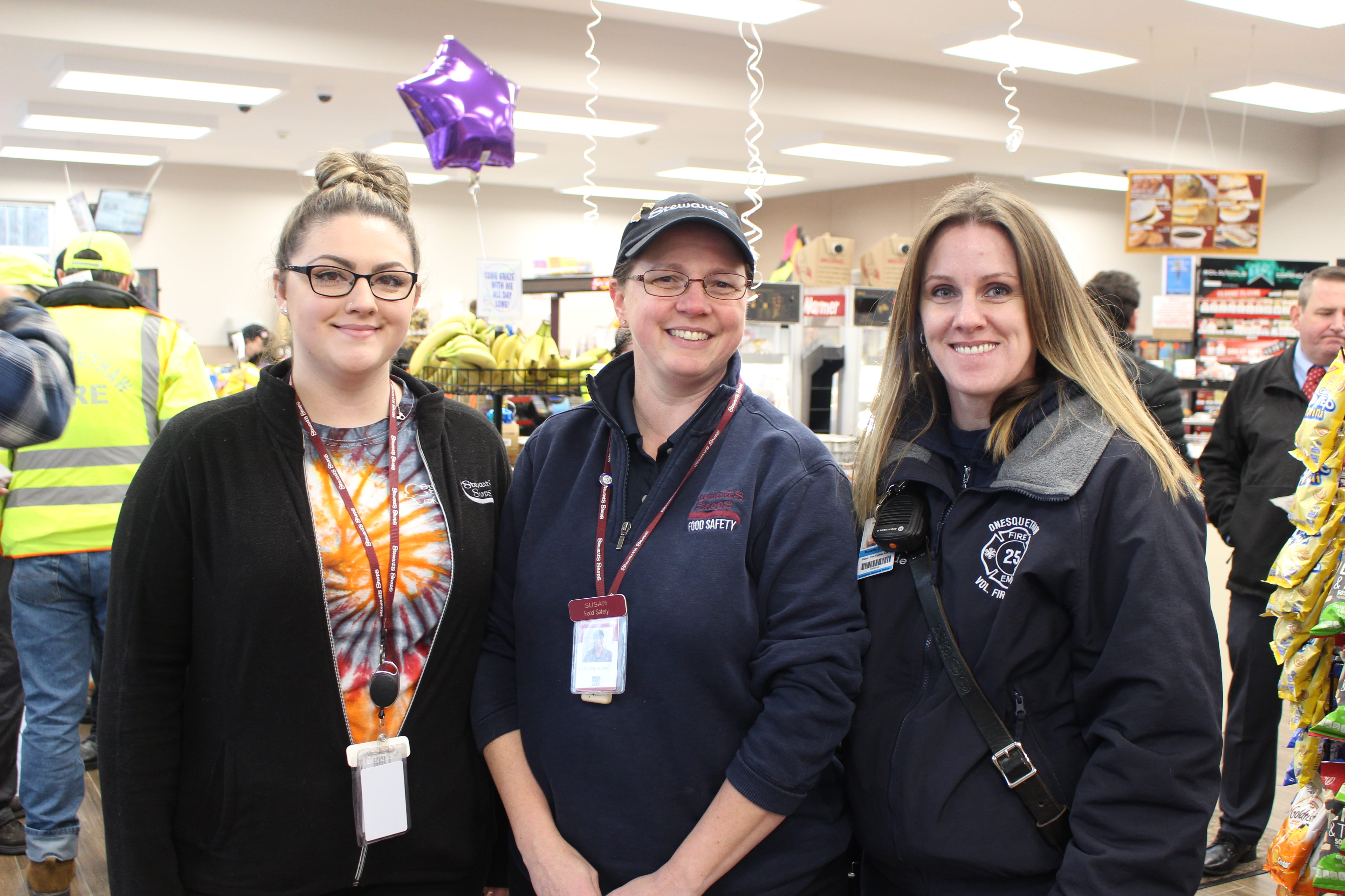 two stewarts team members with an EMT at the grand opening event