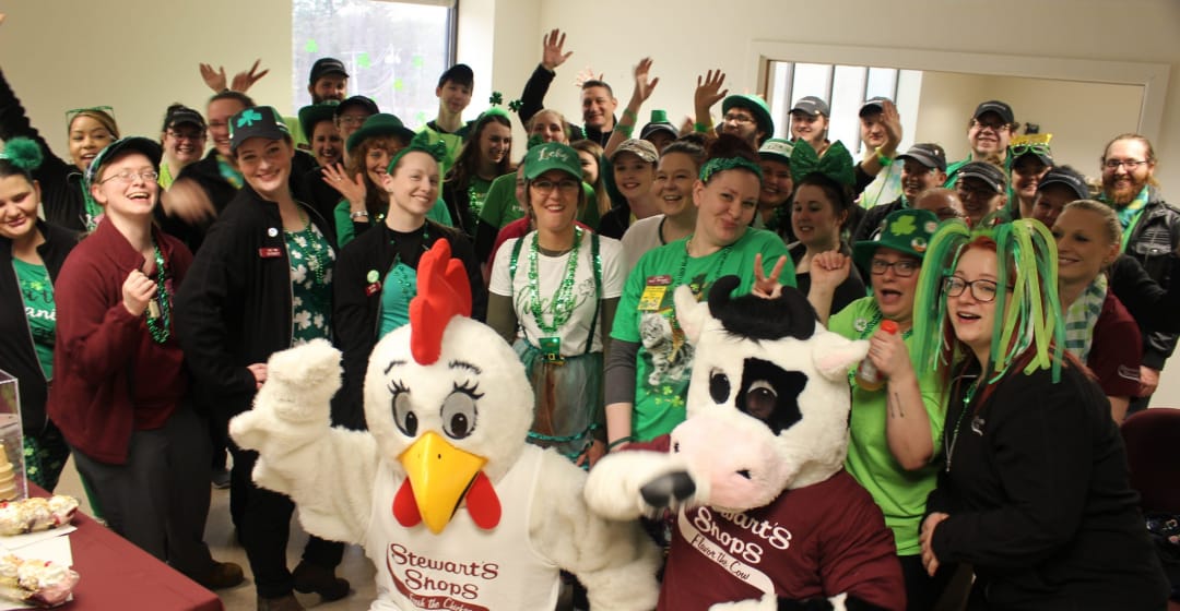 Group of Stewarts Partners and the mascots dressed in green