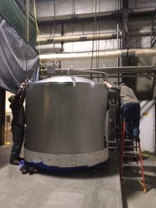 two men working on a tank