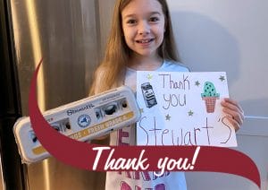 A little girl holding eggs and a sign that says thank you Stewarts. Thank you