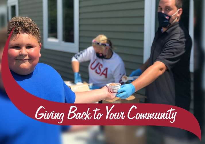 Camper receiving ice cream from camp counselor.