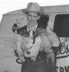 Actor holding Perky and Patches, lamb mascots