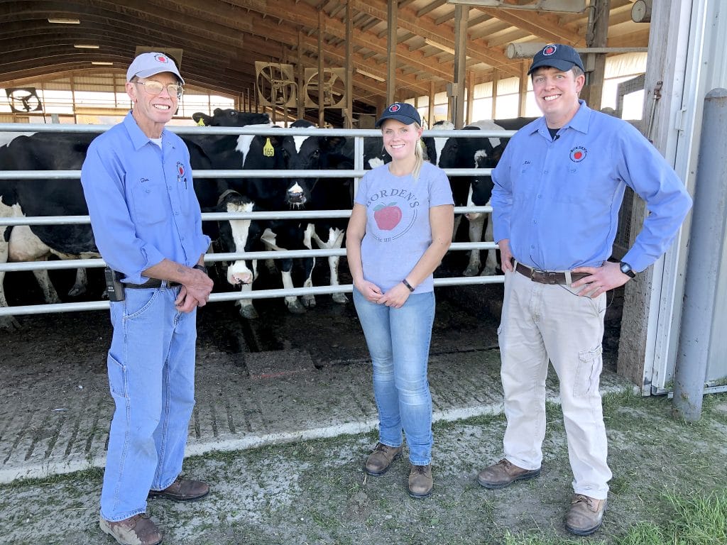 Three farmers with their cows