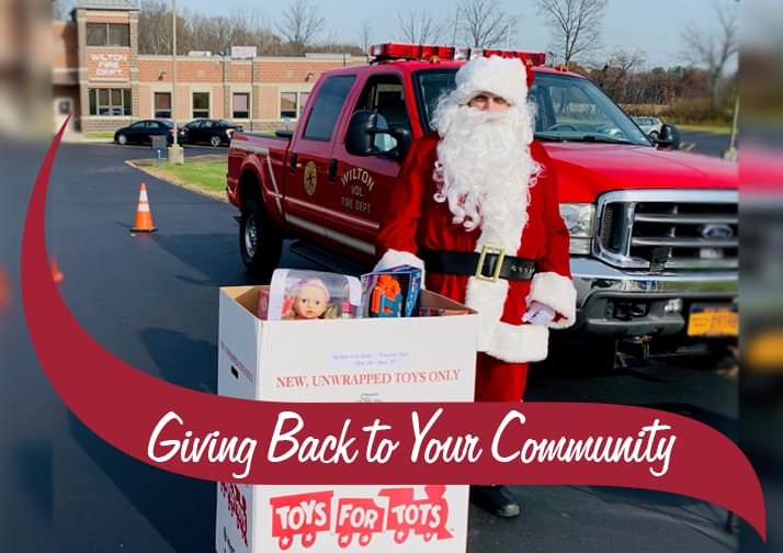 Santa standing with a box of toys for tots collections.