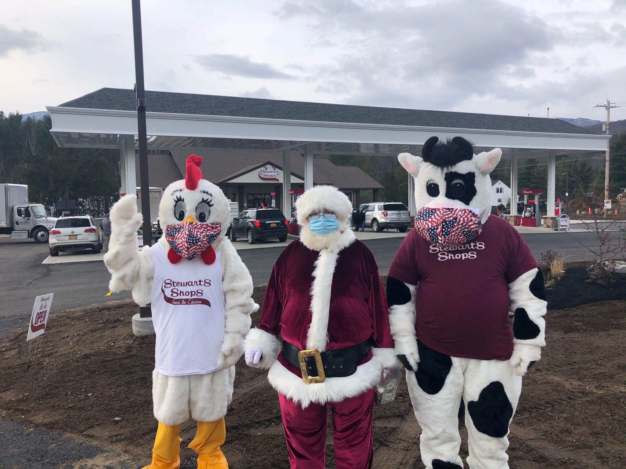 Chicken and Cow mascots with Santa in front of Shop