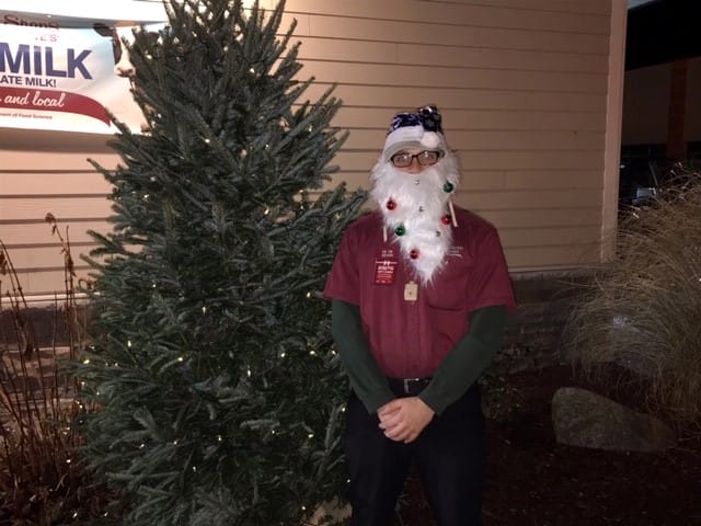 Partner dressed with fake santa beard posing with our Christmas tree