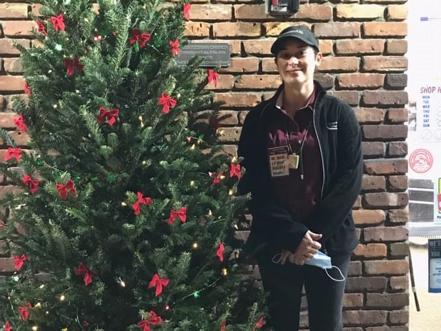 Partner at Woodlawn shop posing with our Christmas tree