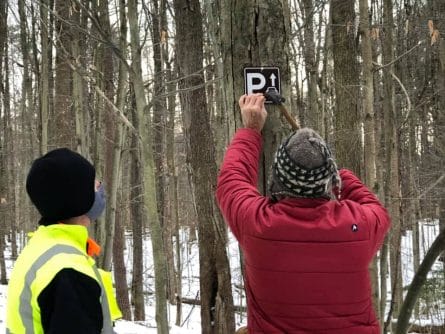 Oswego Co Search & Rescue nailing in trail marker signs