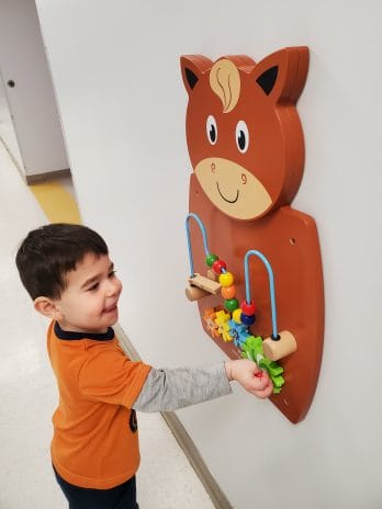 Child playing with a sensory board at the YMCA.