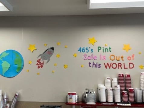 Shop decorations saying "465's Pint Sale is Out of this WORLD" with a rocket ship