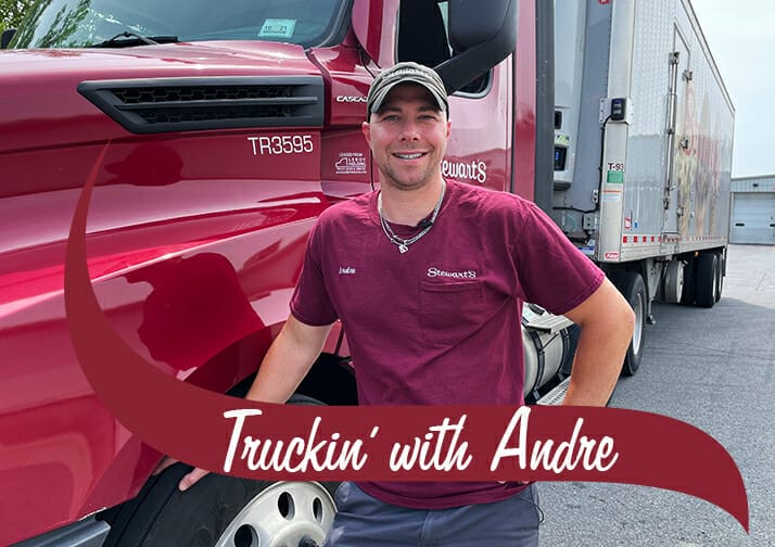 Andre a Stewarts truck driver standing by his truck. The words read Truckin with Andre