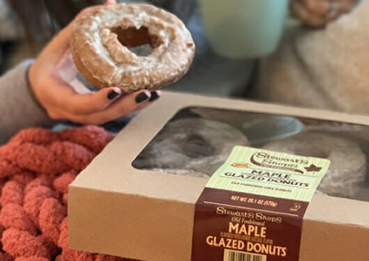 Customer holding a box of maple donuts