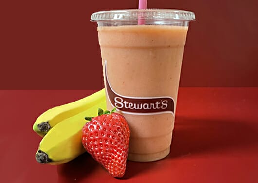 Strawberry banana smoothie with bananas and strawberries on the side