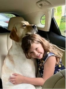 BluePath dog giving a girl a hug