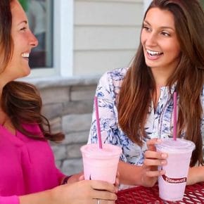 two women drinking milkshakes.