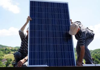 2 people installing solar panels. 