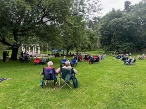 people sitting in park enjoying music 