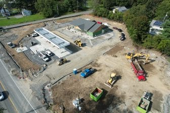 Drone photo of the shop. Dirt ground with construction vehicles around it. 