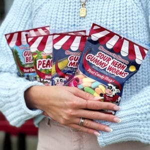 person holding 4 bags of stewart's candy.