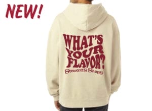 New in the top left corner. What's Your Flavor written in maroon wavy font on the back of a tan oversized hoodie. 