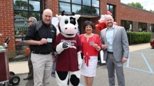 Flavor the Cow and three people holding certificates for a Stewart's prepackaged pint. 