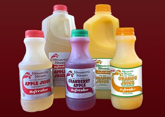 Stewarts Juice Refreshers apple, cranberry apple, and orange juice over a burgundy background