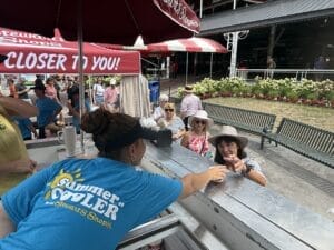 Partner handing customer a free ice cream at Saratoga Race course on the ice cream cart