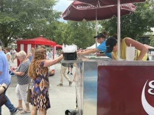 Partner handing smiling customer a free ice cream at Saratoga race course