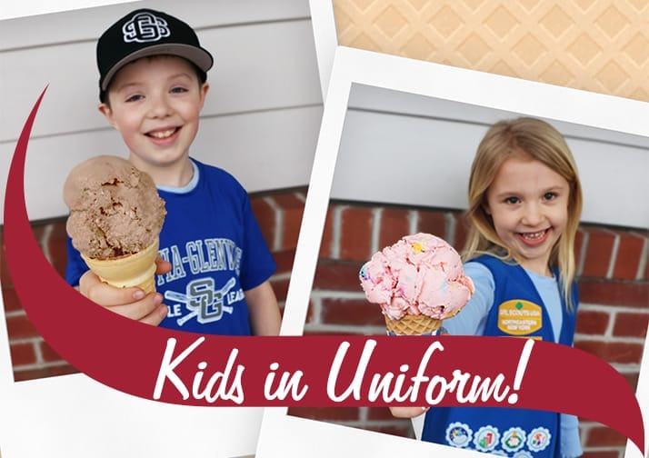 Two kids in uniforms holding up Stewart's ice cream cones.